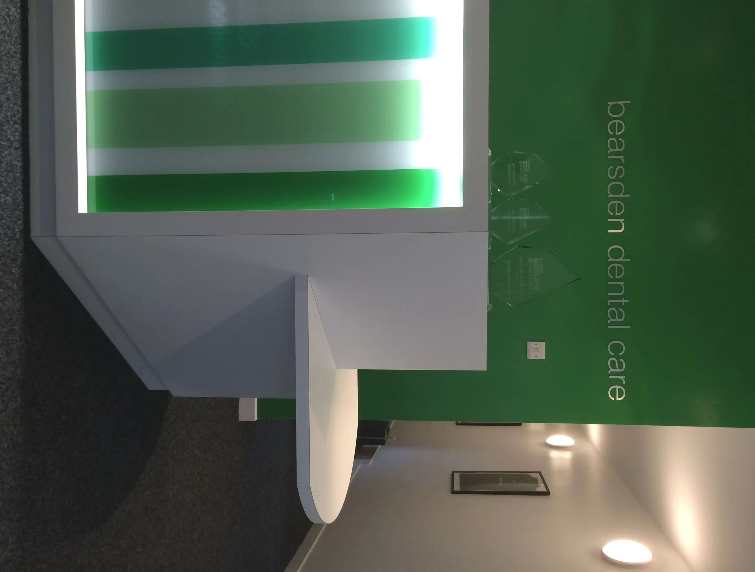 The green-walled reception corridor at Bearsden Dental Care