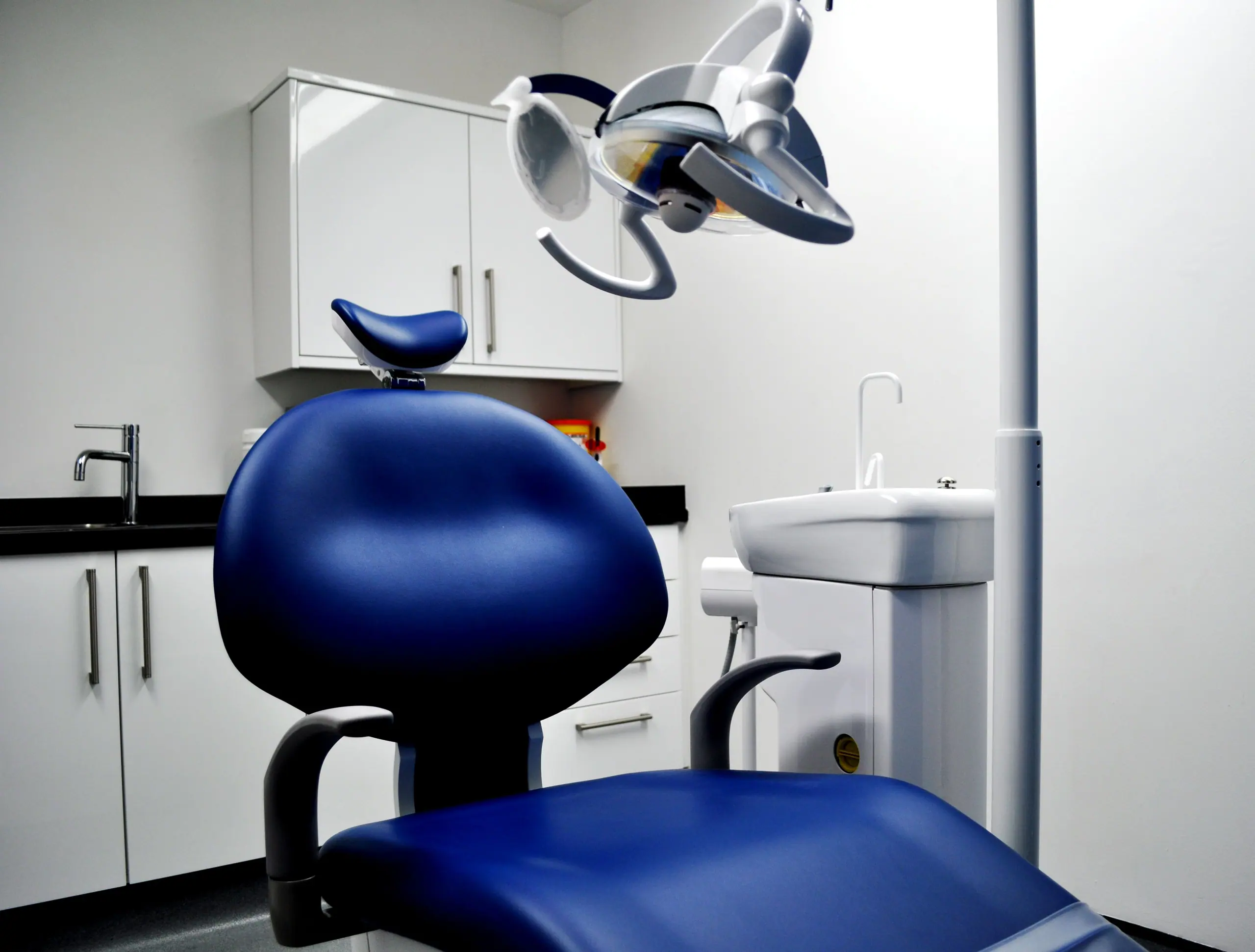 A treatment room at Bearsden Dental Care with a blue dental chair